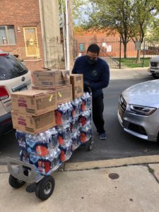 Man unloading supplies at the curb.