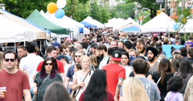 Crowds of people walk on Passyunk Avenue during the Flavors on the Avenue Festival. The street is blocked off.