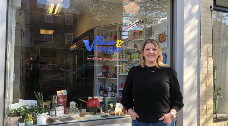 A female-business owner stands in front of her store called Salt & Vinegar.