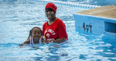 An African-American woman helps a little girl swim in a Philadelphia Public Pool on June 17, 2024.